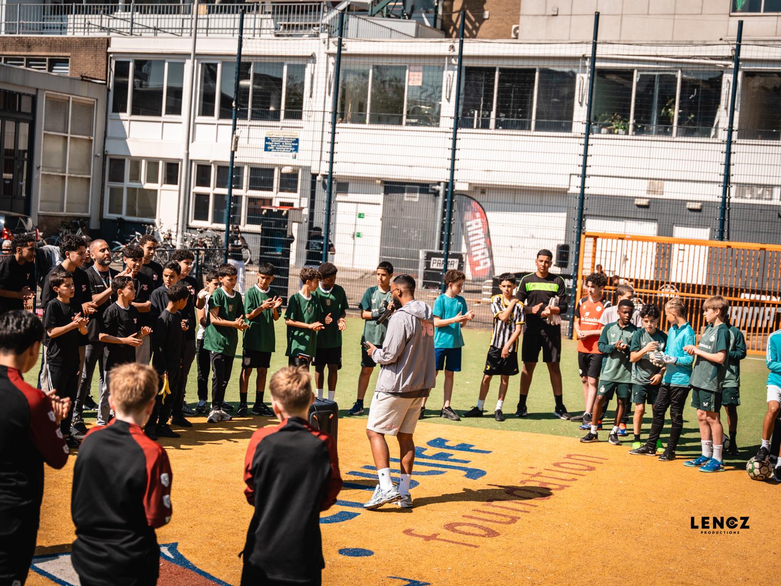 Trainers en jongeren op het voetbalplein tijdens een activiteit